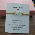 Detailed view of infinity symbol wish bracelet with yellow cord on card. - Infinity Symbol (EB0168) / Mustard Yellow