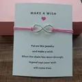 Close-up detail of a silver infinity symbol on a pink string wish bracelet card - Infinity Symbol (EB0168) / Pink