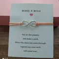 Detailed view of infinity charm bracelet on Make a Wish card with peach cord string - Infinity Symbol (EB0168) / Watermelon red