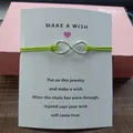 Green string infinity symbol charm bracelet on a white Make A Wish blessing card - Infinity Symbol (EB0168) / Fluorescent Green