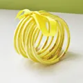 Set of nine yellow glitter jelly bangles tied with a ribbon bow for accessories - 9 Pieces Set / Yellow