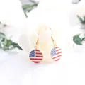 Close-up of gold drop earrings with US flag enamel charm for Independence Day - Round Shape