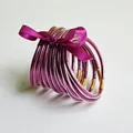 Set van 12 magenta glitter jelly armbanden versierd met een satijnen strik goud. - Magenta