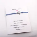 Handmade blue cord wish bracelet featuring a silver turtle charm on a white gift card - Blue