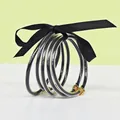 Set of 5 stylish black glitter silicone bangles with gold lotus clasp and black ribbon - 5 Pieces / Black