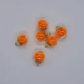 Close-up of 16mm transparent round glass pendants filled with orange foam beads - Orange