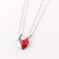 Close-up of split heart-shaped magnetic necklaces in red and silver joined together - Black Red Pendant