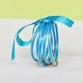 Set of five vibrant blue silicone glitter bangles featuring golden lotus clasps and silk ribbon - 5 Pieces / Sky Blue