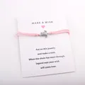 Bracelet à vœux en cordon rose avec breloque tortue sur une carte de présentation blanche - Rose