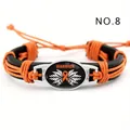 Primer plano de una pulsera de cuero trenzado con cinta naranja y colgante 'WARRIOR'. - Guerrero Naranja (NO.8)