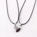 Close-up of faceted magnetic heart-shaped pendants on black cord necklaces for couples - Black