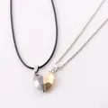 Close-up of magnetic heart-shaped pendant necklace set for couples in gold and silver finish - Black & Gold Pendant