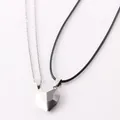 Close-up detail of magnetic heart shaped couple necklaces with black and white pendants - Black and White Pendant