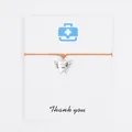 Detailed view of orange wax rope bracelet with winged tooth charm on Thank You card - Orange