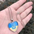Vista macro di un ciondolo a forma di cuore con la bandiera e lo stemma dell'Ucraina - Stile Cuore - Emblema dell'Ucraina