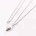 Magnetic heart couple necklaces set with silver geometric pendants on white background - White