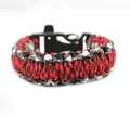 Close-up of red and black woven paracord survival bracelet with tactical whistle buckle - Plastic Whistle Buckle Style / Red