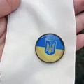 Detailed view of a vintage round brooch featuring the Ukrainian flag and coat of arms. - Ukraine Flag