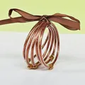 Set of 5 copper glitter silicone bangles with brown ribbon and gold lotus clasp. - 5 Pieces / Dark Rose Gold
