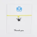 Close-up of angel tooth charm bracelet on a 'Thank you' card with yellow wax cord. - Yellow