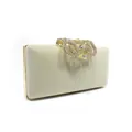 Detailed view of luxury velvet clutch bag featuring a stunning rhinestone crown clasp. - Beige