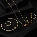 Detailansicht eines goldenen Knotenschmuck-Sets mit Halskette, Armband, Ring und Ohrringen. - Set / Gold