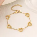 Elegantes goldenes Edelstahlarmband mit fünf hohlen Herzanhängern auf weißem Grund. - Herz Armband (Gold)