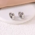 Detailansicht von silbernen Creolen aus Edelstahl mit achtzackigem Stern und Zirkonia - Achtzackiger Stern Stil / Silber