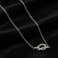 Close-up detail of silver stainless steel necklace featuring a minimalist knot pendant design - Necklace / Silver