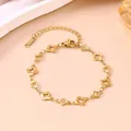 Detailansicht eines vergoldeten Edelstahlarmbands mit hohlen Kleeblatt-Motiven - Armband / Gold