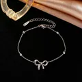Primer plano de una pulsera de acero de titanio plateada con lazo y cuentas elegantes. - Pulsera / Color acero