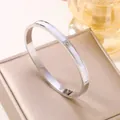 Detailansicht eines silbernen Armreifs aus Edelstahl mit Muscheleinlage und drei Kristallen. - Muschel Inlay Zirkonia Armreif / Silber