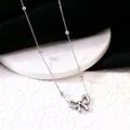 Detailopname van een gepolijste zilveren titanium stalen armband met een strikje. - Ketting / Staalkleur