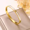 Detailansicht eines 18k vergoldeten Titanstahlarmbands mit weißer Muschel und drei Steinen - Muschel Armreif / Gold