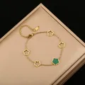 Primer plano de una pulsera bañada en oro con flores de cinco pétalos y motivo de malaquita - Negro y Verde de Doble Cara