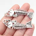 Vintage silver-tone fish bone charms pendants held in hand showing 56x18mm size details - Antique Silver