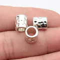 Hammered silver metal tube beads shown on fingertips for scale and texture detail. - 10 Pieces Pack / Antique Silver