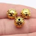 Premium 10mm golden metal spacer beads with vintage swirl texture displayed on a finger - Antique Gold