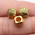 Antike goldene Großlochperlen mit schwarzer Wellenstruktur für Schmuck und Dreadlock-Zöpfe - Altgold