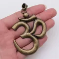 Grote vintage bronzen Om yoga symbool hanger in de hand gehouden voor de schaal - Extra Grote OM Yoga Symbool Hanger (A12945) / Antiek Brons
