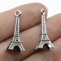 Silver-toned 3D Eiffel Tower pendants for DIY jewelry making shown on fingertips - 3D Tower Style (B14012) / Antique Silver