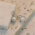 Eleganti orecchini pendenti con perle naturali e ganci in argento S925 su sfondo pietra - Orecchini Perla Argento Sterling