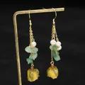 Elegant long dangle earrings with natural pearls, green stones and yellow flower buds. - Preserved Flower Earrings
