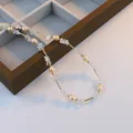 Collier élégant avec cristaux blancs et perles naturelles sur présentoir en bois. - Cristal Blanc avec Collier en Perles Roses