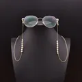 Cadena de gafas dorada con perlas naturales blancas en un soporte de maniquí negro - Correa de Perlas de Agua Dulce Naturales / Dorado