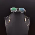 Elegant gold-toned eyeglass chain featuring natural pearls and crystal seashell pendants - Asymmetrical Eyeglass Chain