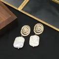 Elegant 18k gold-plated spiral earrings with natural baroque pearl drops - White Lollipop Studs