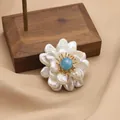 Elegant flower brooch featuring natural pearls and a blue stone center on fabric. - Aquamarine Three-Layer Flower Style (GO0332C)