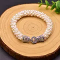 Elegant braided natural white pearl bracelet with sparkling crystal clasp on wooden surface - Luxurious Small Pearl Bracelet / Multi-layer Braided Style / White