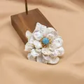 Elegant natural freshwater pearl flower brooch with a blue stone center on a wooden stand - Three-Layer Pearl Blue Stone Style (GO0332C)